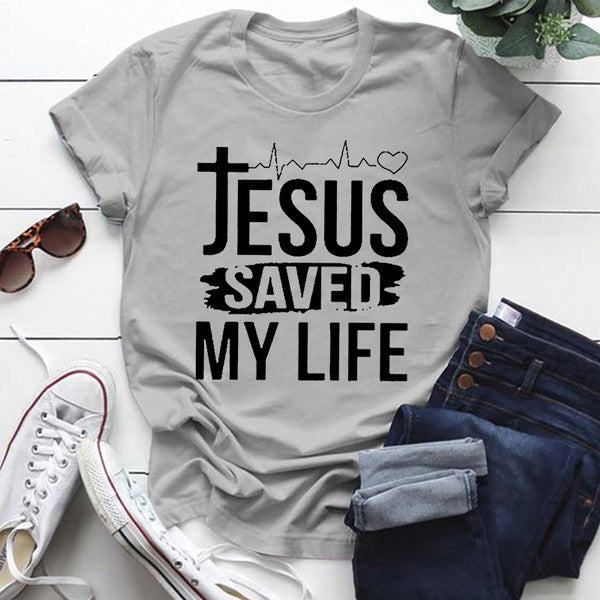 Jesus Saved My Life Short Sleeve T-shirt displayed on a flat lay with accessories and jeans, showcasing its stylish design.